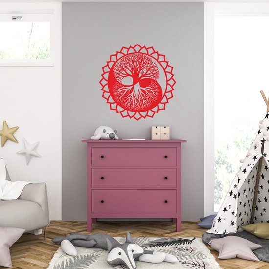 Rode muursticker van een yin yang levensboom in een lotusvorm, geplaatst op een grijze muur boven een roze ladekast.