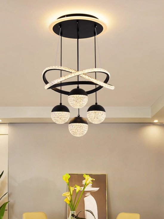 Un lustre moderne avec quatre abat-jours sphériques en cristal sur des cordons noirs, avec une décoration d'anneau noire et dorée.