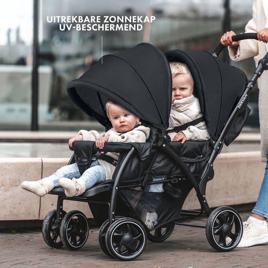 Zwarte dubbele buggy met twee kinderen, de zonneschermen zijn uitgeschoven.