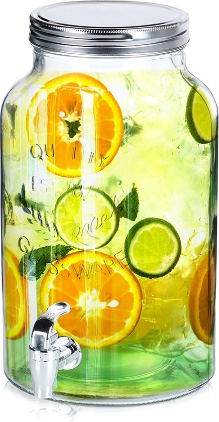 Distributeur de boissons en verre avec couvercle argenté, rempli d'eau, de glace, de tranches d'orange et de citron. Avec robinet.