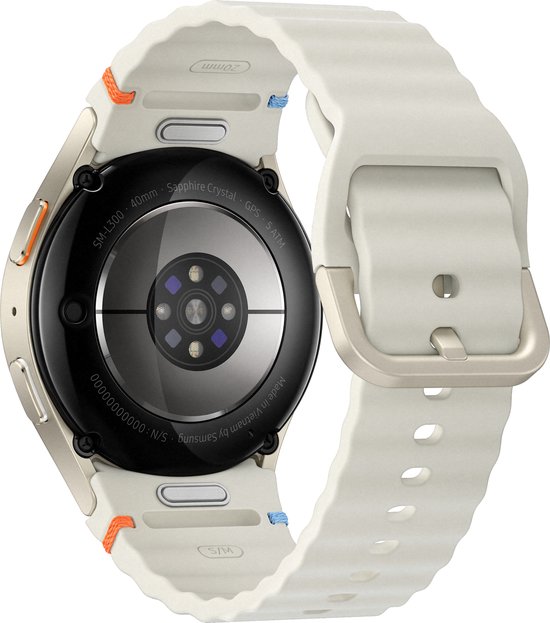 Achterkant van een crèmekleurige smartwatch met wit bandje. De achterkant is van glas en toont sensoren.