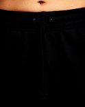 Close-up van de tailleband met trekkoord van een zwarte joggingbroek.