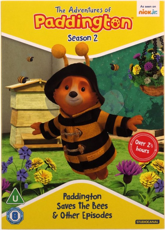 Paddington in bijenkostuum met hoed, vliegend in een tuin met bijenkasten en bloemen. 'The Adventures of Paddington Season 2' staat bovenaan.