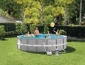 Een gezin geniet van een opzetzwembad in de tuin, met een Intex zoutwatersysteem erbij.