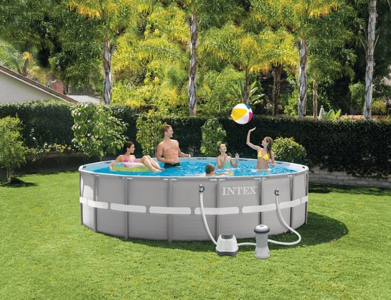 Een gezin geniet van een opzetzwembad in de tuin, met een Intex zoutwatersysteem erbij.