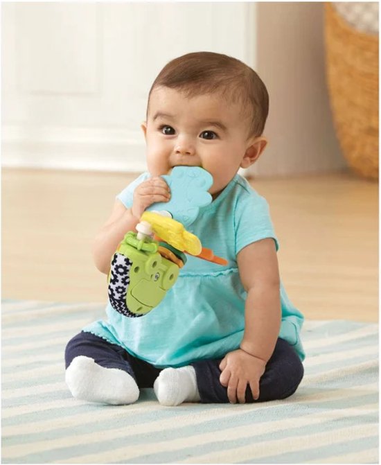 Baby in blauw shirtje bijt op lichtblauwe en gele onderdelen van de VTech rammelsleutel.