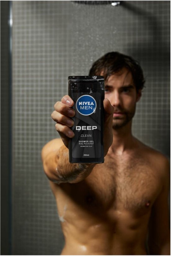 Man in de douche houdt een zwarte NIVEA fles met etiket 'DEEP CLEAN SHOWER GEL' naar de camera.