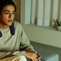 Man met zwarte nekband speaker om zijn nek.