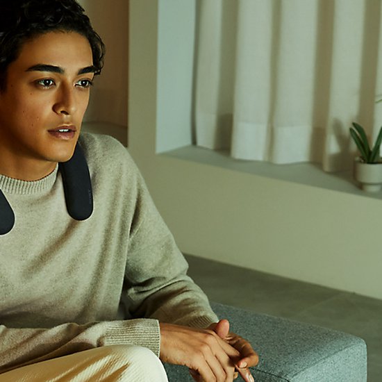 Man met zwarte nekband speaker om zijn nek.