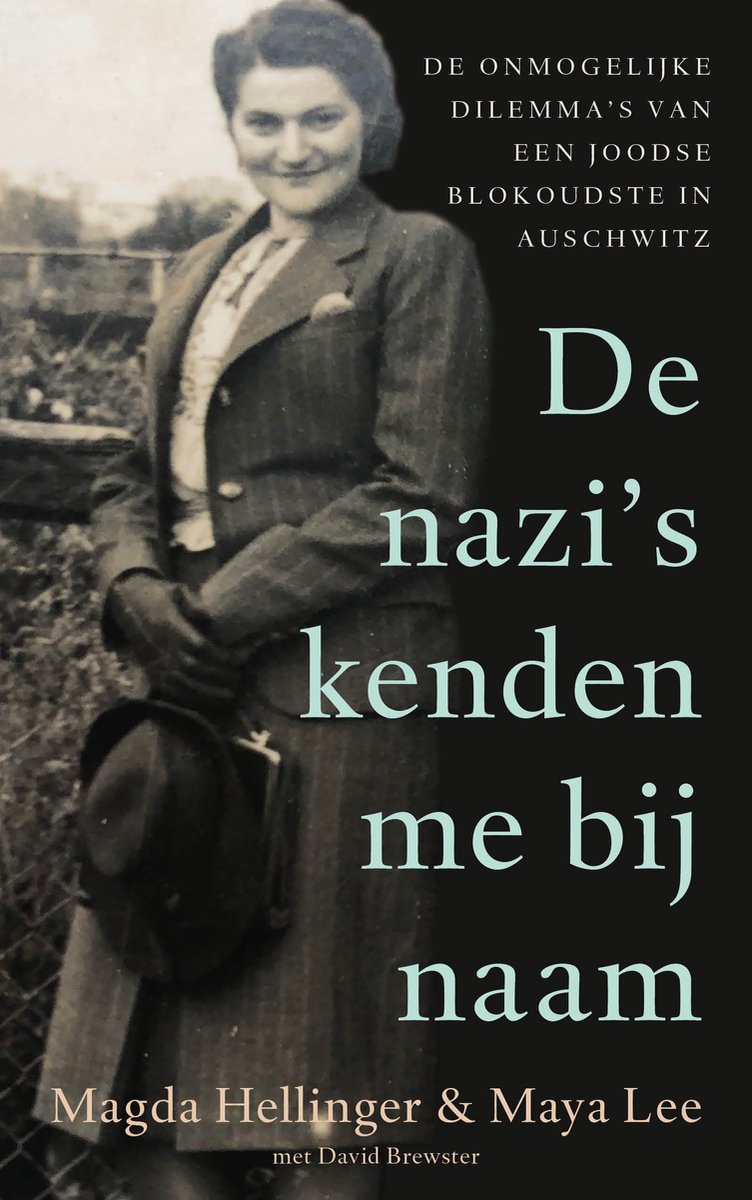 Zwart-wit foto van Magda, een jonge vrouw in klederdracht, met opgestoken haar en hoed in haar handen. Ze kijkt naar de camera met een lichte glimlach.