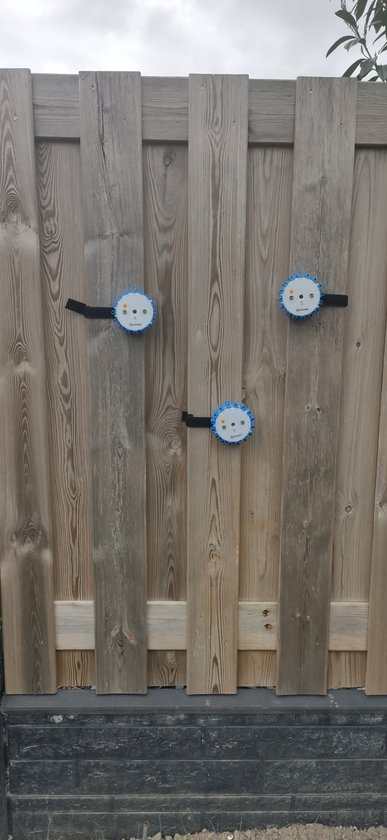 Drie blauwe reaction lights bevestigd aan een houten schutting.