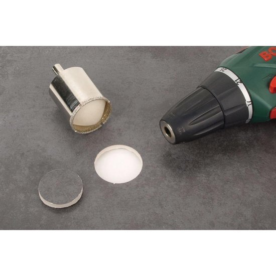 Zilverkleurige diamantboor met witte binnenkant, een ronde schijf en een groene boormachine.