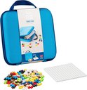 Blauwe Plus-Plus reiskoffer met ritssluiting, gevuld met 100 kleurrijke bouwstenen, een wit bord en een opengewerkt deksel waarop een figuur is te zien.