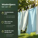 Gekleurde kleding hangend aan een waslijn, vastgezet met zwarte en witte knijpers.