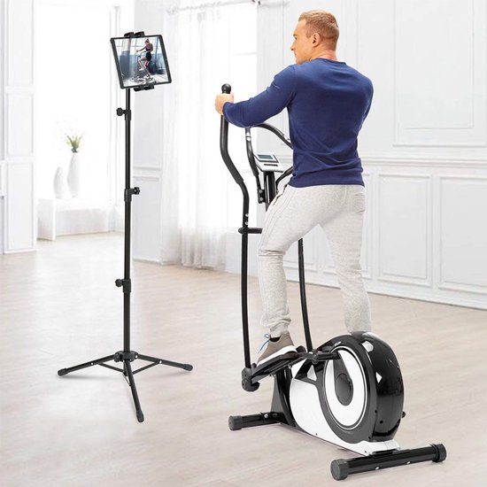 Man traint op een crosstrainer, met een tablet op een driepootstandaard die een les toont.