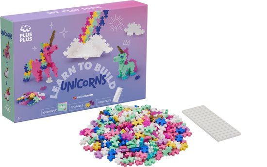 Plus-Plus doos met eenhoorns. Naast de doos liggen kleurrijke bouwstenen en een witte baseplate.