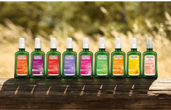 Rij van negen groene Weleda flesjes met verschillende kleuren etiketten.