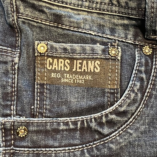 Detail van de voorkant van een stonewashed blauwe jeans met het Cars Jeans label en kenmerkende zakken.