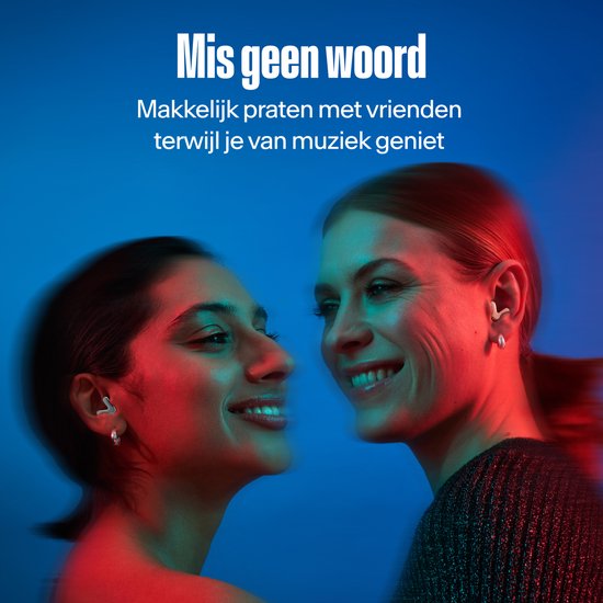 Twee vrouwen glimlachen, kijkend naar elkaar, met rosé gouden oordopjes. Blauwe en rode belichting.