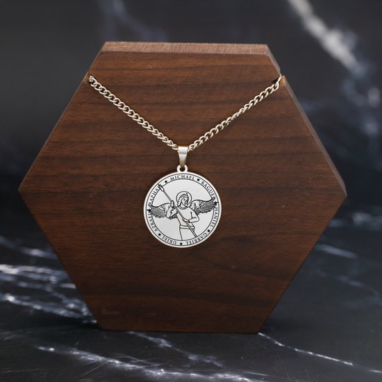 Zilverkleurige ketting met ronde engel hanger op houten display.