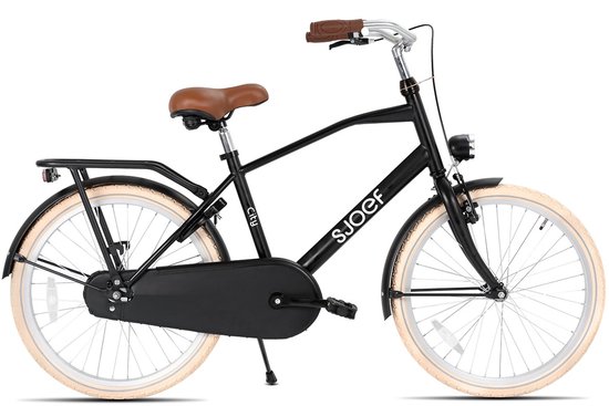 Vélo enfant noir mat avec selle marron, porte-bagages et pneus crème.
