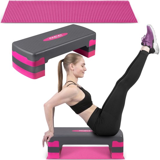 Een vrouw ligt op haar rug en tilt haar benen op, gebruikmakend van een grijze aerostep met roze accenten en een roze mat.