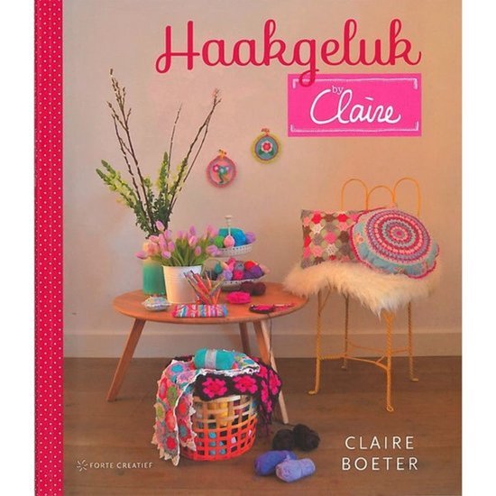Boekomslag 'Haakgeluk by Claire' met een decoratief tafereel van gehaakte kussens, mand en bloemen.