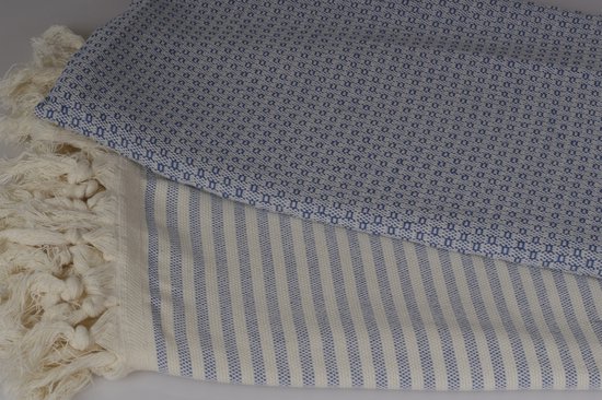 Gedetailleerde close-up van een blauwe hamamdoek met een ruitpatroon en gestreepte rand met franjes.