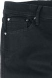Detail van de voorkant van een zwarte skinny jeans, met zakken en zilverkleurige knopen.