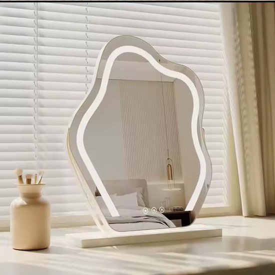 Golvende spiegel met ledverlichting op een witte basis, geplaatst op een vensterbank met uitzicht op een slaapkamer.