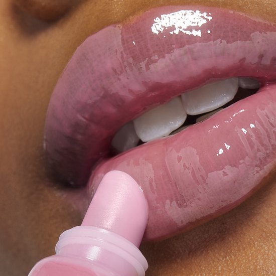 Close-up van lippen met glinsterende roze Lancôme Juicy Tubes lipgloss, terwijl een tube gloss aanbrengt.