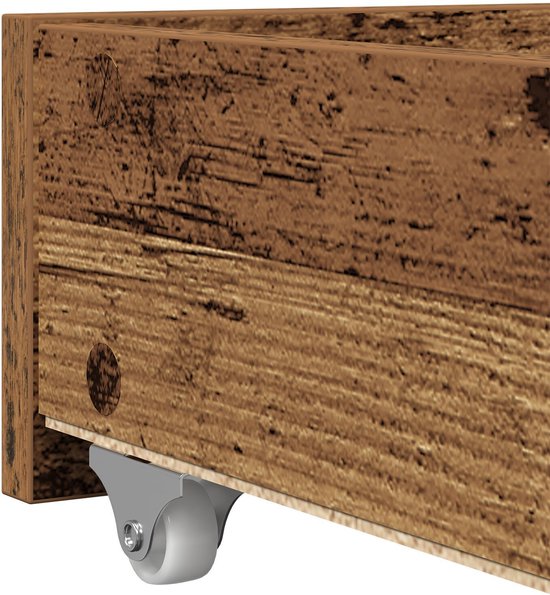 Klapwieltje onder een bruin, verweerd houten bedframe.