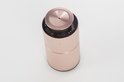 Schuine weergave van de bovenkant van een rose gouden diffuser met een gecentreerd, cirkelvormig gesatineerd element en knoppen.