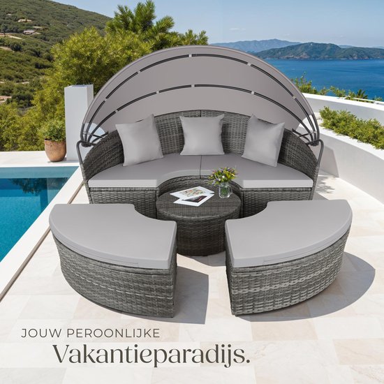 Grijs, rond loungebed met zonnescherm, kussens en tafel bij een zwembad en zee. Creëert een persoonlijk vakantieparadijs.