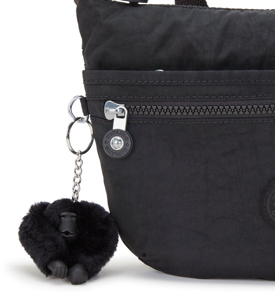 Detail van een zwarte Kipling tas met een rits en een zwart aapje als sleutelhanger.