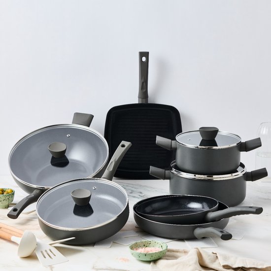 Un ensemble de casseroles et poêles noires avec couvercles en verre et poignées grises.