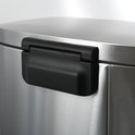 Detail van het zwarte scharnier op de deksel van een RVS pedaalemmer.