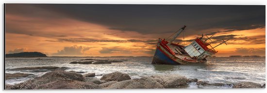 Dibond - Zakkend Scheepswrak bij Rotsen in de Zee bij Zonsondergang - 60x20 cm Foto op Aluminium (Wanddecoratie van metaal)