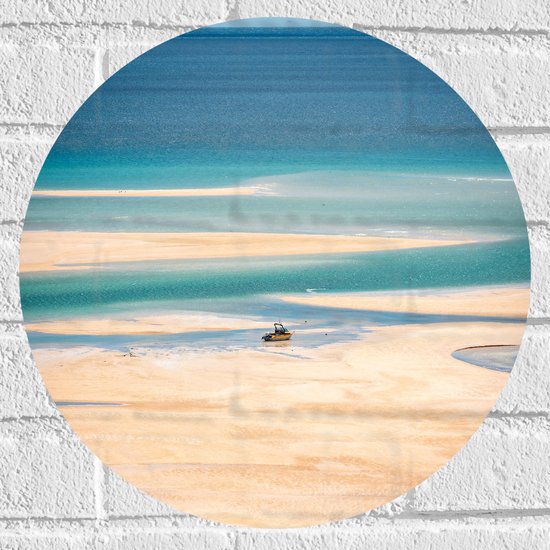Ronde muursticker met een zonnig strand, helderblauw water en een kleine boot op het zand.