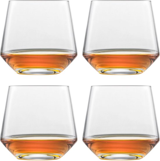 Quatre verres à whisky en cristal remplis d'une boisson ambrée, de forme large et effilée avec un fond épais.