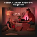 Deux femmes dans un salon avec un éclairage d'ambiance rose Philips Hue Play.