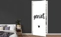 Porte blanche avec le texte noir 'geniet' et un petit cœur, dans une chambre.