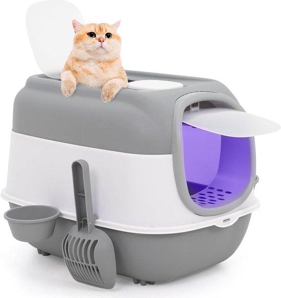 Grijze en witte kattenbak met een oranje kat die erin zit, met schep en bakje aan de zijkant.