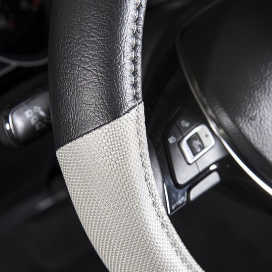 Close-up van stuurhoes met zwart lederlook, grijs textiel en stiksels, bij autostuur.