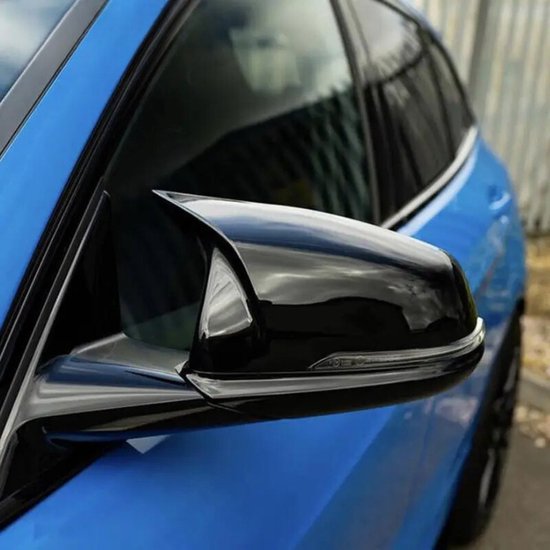 Zwarte glimmende buitenspiegel op een blauwe auto, met indicatorlampje.