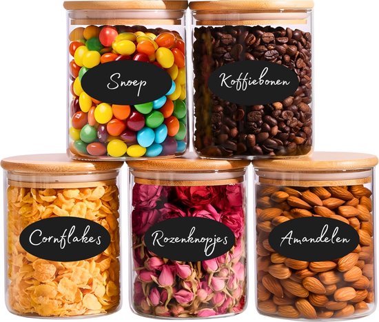 Cinq bocaux en verre avec couvercles en bambou. Remplis de bonbons, grains de café, cornflakes, boutons de rose et amandes.