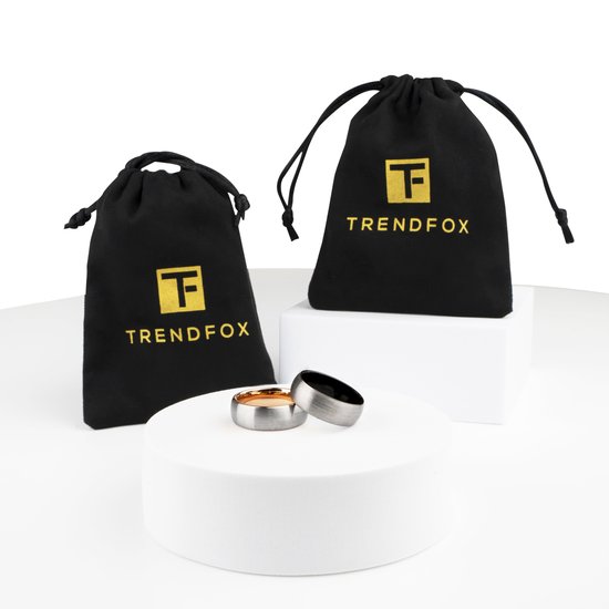 Twee ringen op een witte sokkel met twee zwarte TrendFox zakjes.