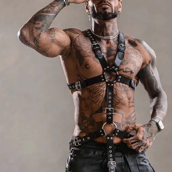 Man met zwart kunstleren harnas, gespen, ringen, tattoos, zonnebril.