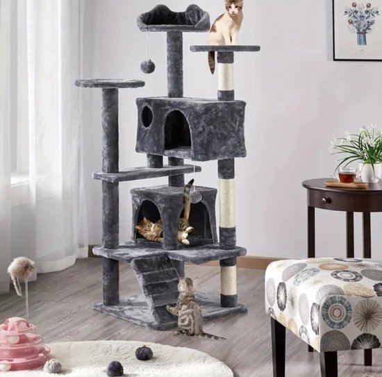 Grote, grijze kattenkrabpaal met meerdere verdiepingen, huisjes en zitplaatsen, in een woonkamer.