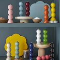 Gekleurde peper- en zoutmolens gestapeld op planken. Kleuren: roze, blauw, bordeaux, oranje, geel, wit, groen, zwart.